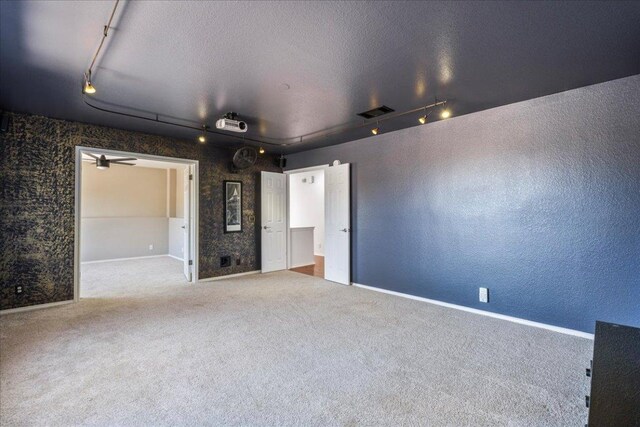 12413 Fairfax Ridge Pl, Austin, TX 78738 - spare room featuring rail lighting, carpet floors, a textured wall, and a textured ceiling