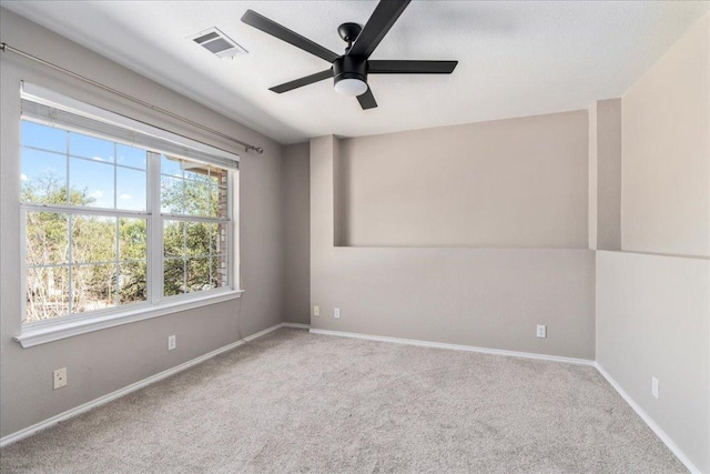 carpeted spare room with a ceiling fan and baseboards
