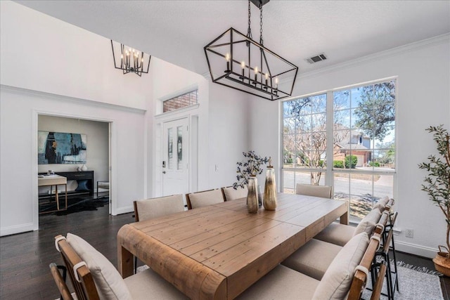dining room featuring a chandelier, baseboards, dark wood finished floors, and ornamental molding