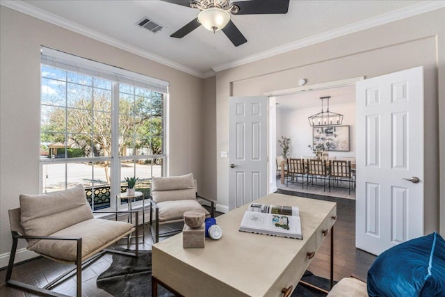 sitting room featuring dark wood-style floors, a chandelier, a ceiling fan, crown molding, and baseboards