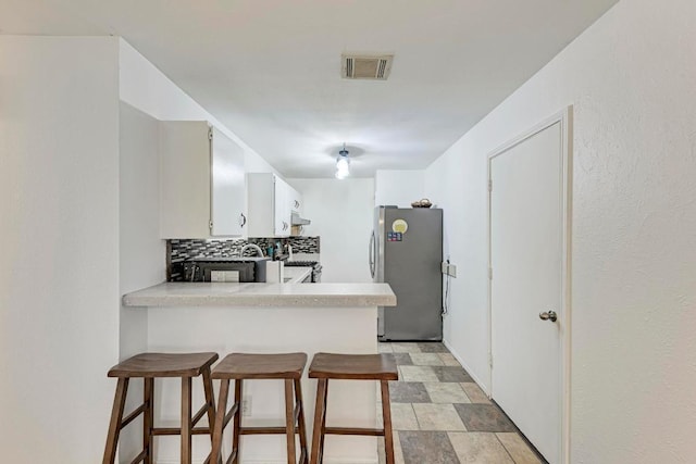 8610 Croydon Loop, Austin, TX 78748 - kitchen featuring light countertops, decorative backsplash, freestanding refrigerator, and visible vents