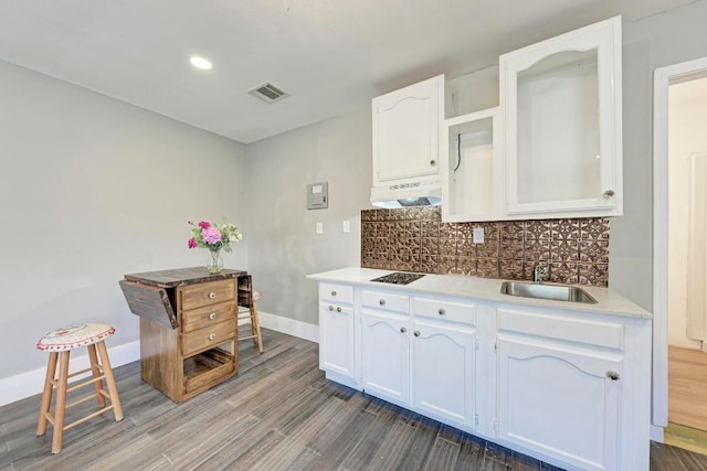 8610 Croydon Loop, Austin, TX 78748 - kitchen with under cabinet range hood, white cabinets, dark wood-type flooring, decorative backsplash, and black electric cooktop