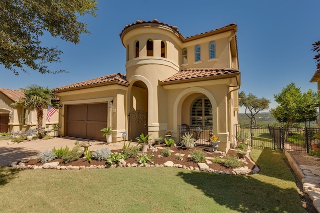 mediterranean / spanish home with fence, a front lawn, stucco siding, a tiled roof, and driveway