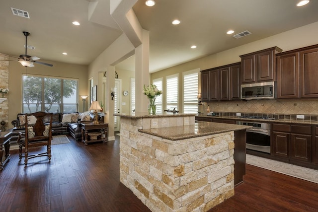 kitchen with visible vents, open floor plan, appliances with stainless steel finishes, and a ceiling fan