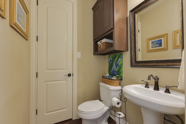 half bathroom featuring a sink and toilet