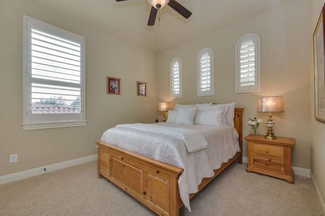 bedroom with a ceiling fan, baseboards, and light colored carpet