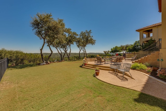 view of yard with stairs, a fenced backyard, and a patio area