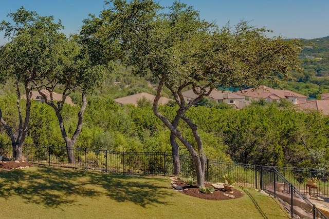 view of home's community with fence and a yard