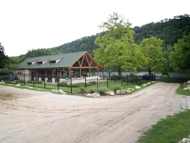 view of home's community with fence and dirt driveway