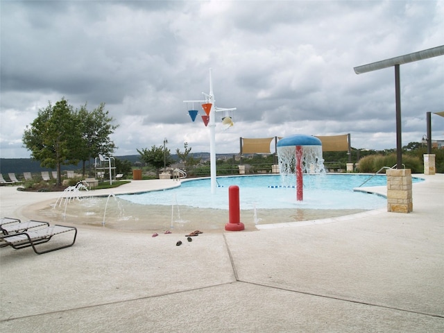 view of property's community featuring a patio area and a pool