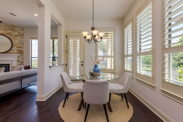 11521 Shadestone Ter, Austin, TX 78732 - dining area featuring a chandelier, dark wood-style floors, and a fireplace