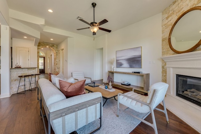 11521 Shadestone Ter, Austin, TX 78732 - living area featuring dark wood-type flooring, a glass covered fireplace, arched walkways, a ceiling fan, and recessed lighting