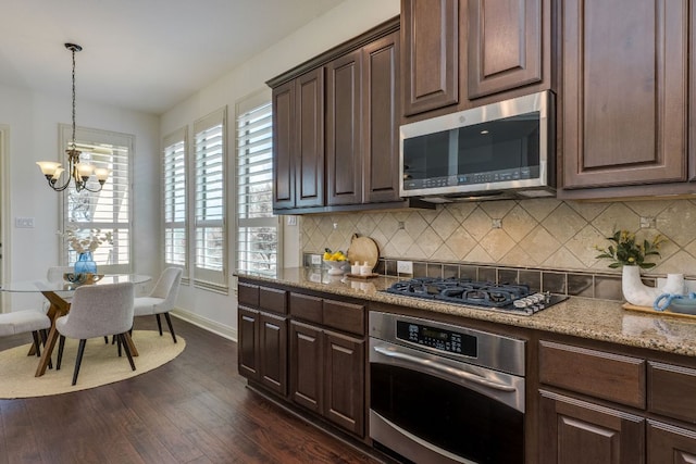 11521 Shadestone Ter, Austin, TX 78732 - kitchen featuring stainless steel appliances, a chandelier, dark wood finished floors, tasteful backsplash, and light stone counters