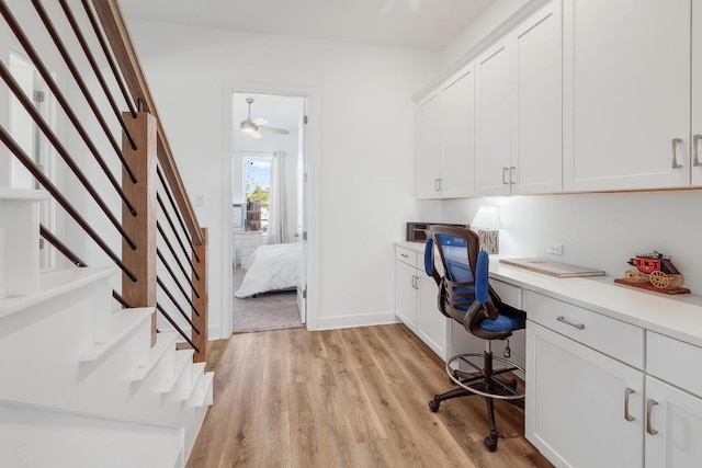 home office with baseboards, light wood-type flooring, and built in study area