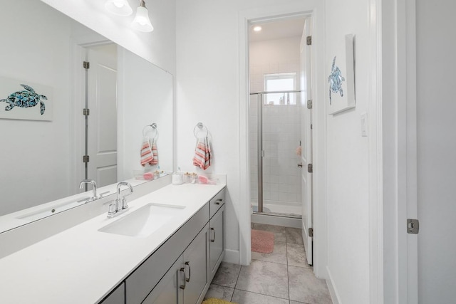 bathroom with tile patterned floors, baseboards, a shower stall, and vanity