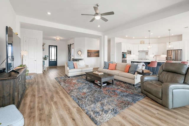 living room featuring recessed lighting, light wood finished floors, and ceiling fan