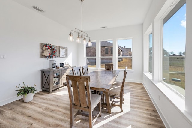 dining space with light wood-style flooring, baseboards, and visible vents