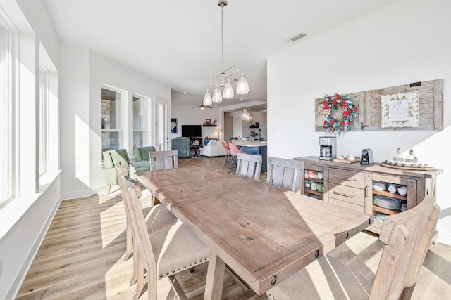 dining space featuring baseboards, visible vents, and light wood finished floors