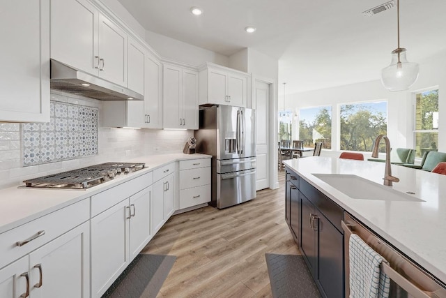 kitchen with visible vents, a sink, light countertops, appliances with stainless steel finishes, and under cabinet range hood