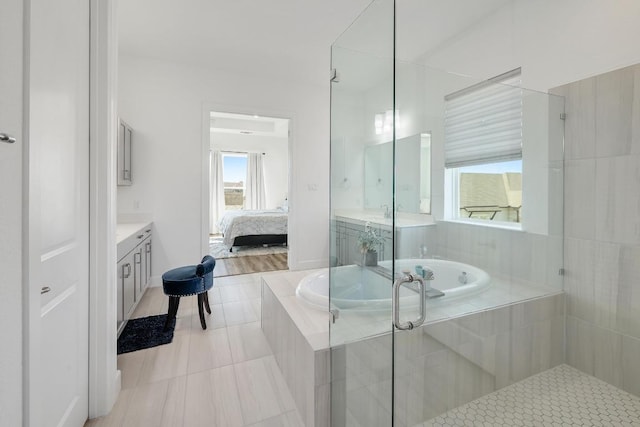 ensuite bathroom featuring a garden tub, a stall shower, ensuite bath, tile patterned flooring, and vanity
