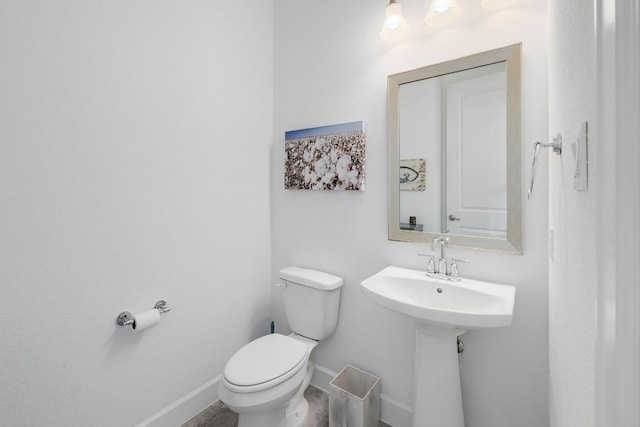 bathroom with toilet and baseboards
