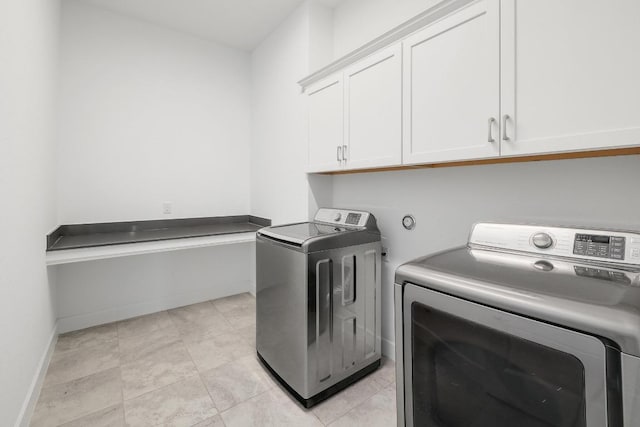 washroom with washer and clothes dryer, cabinet space, and baseboards
