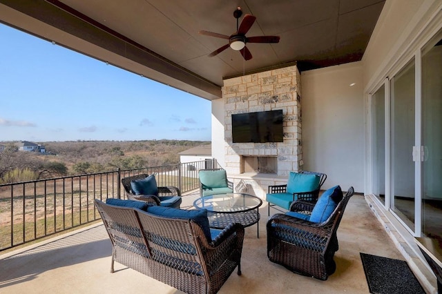 view of patio / terrace with a ceiling fan and an outdoor living space with a fireplace