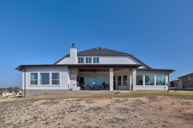 rear view of house featuring a patio area, stucco siding, a chimney, and ceiling fan