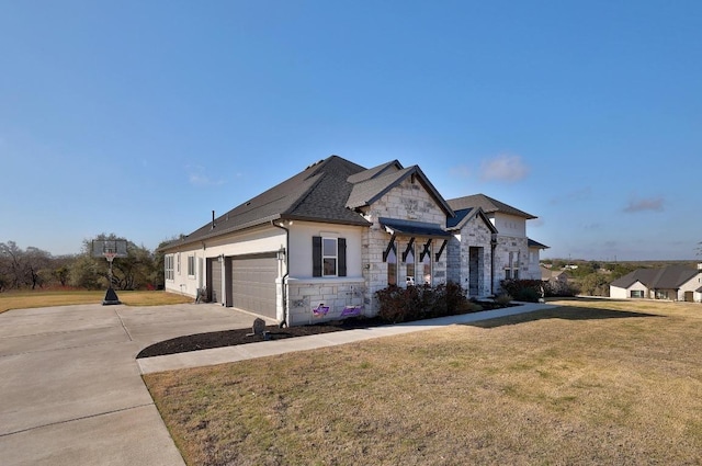 french country inspired facade featuring stone siding, an attached garage, concrete driveway, and a front yard