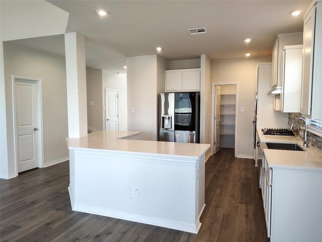 kitchen with visible vents, stainless steel fridge with ice dispenser, light countertops, tasteful backsplash, and a center island