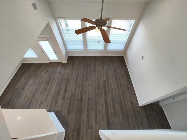 unfurnished living room with baseboards, wood finished floors, visible vents, and ceiling fan