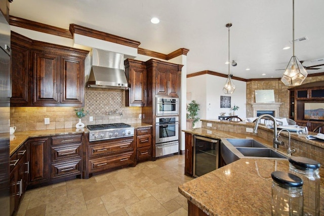 23617 Indian Divide Cv, Spicewood, TX 78669 - kitchen featuring appliances with stainless steel finishes, beverage cooler, a sink, a warming drawer, and wall chimney exhaust hood