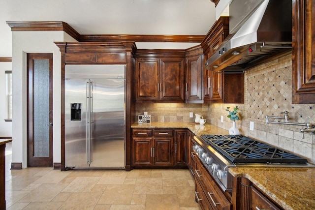 23617 Indian Divide Cv, Spicewood, TX 78669 - kitchen featuring appliances with stainless steel finishes, ventilation hood, light stone counters, tasteful backsplash, and crown molding