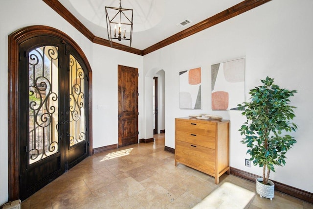 23617 Indian Divide Cv, Spicewood, TX 78669 - foyer featuring arched walkways, french doors, a chandelier, ornamental molding, and baseboards