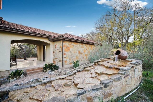 23617 Indian Divide Cv, Spicewood, TX 78669 - view of side of property featuring stone siding and a tiled roof