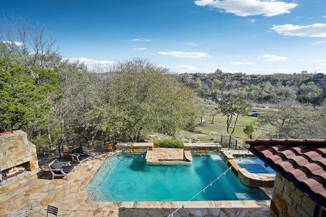 23617 Indian Divide Cv, Spicewood, TX 78669 - view of pool featuring an outdoor stone fireplace, a patio, and a pool with connected hot tub