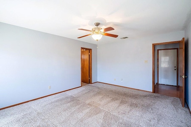 carpeted empty room with visible vents, baseboards, and ceiling fan
