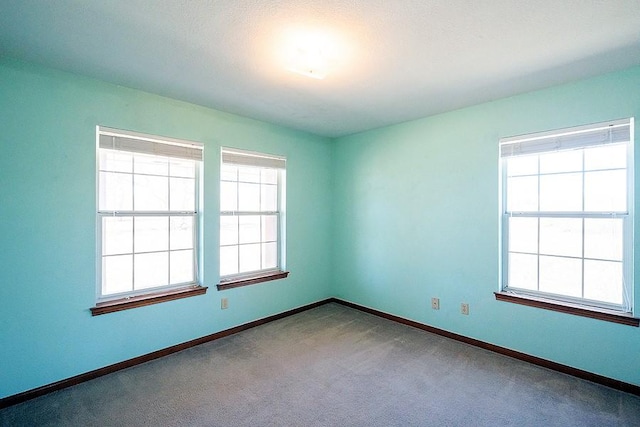 unfurnished room featuring baseboards and carpet flooring