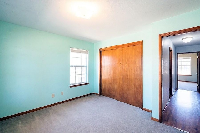 unfurnished bedroom with baseboards, a closet, and carpet floors