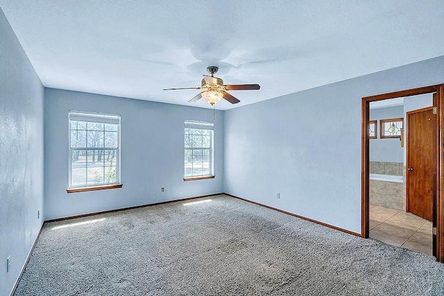 empty room featuring a ceiling fan, baseboards, and carpet floors