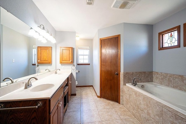 full bathroom featuring visible vents, toilet, a garden tub, tile patterned floors, and a sink