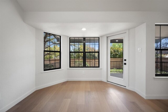 11107 Amblewood Way, Austin, TX 78753 - spare room featuring wood finished floors, baseboards, and plenty of natural light