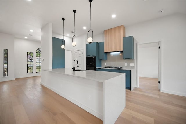 11107 Amblewood Way, Austin, TX 78753 - kitchen featuring light wood-style floors, blue cabinetry, black appliances, light countertops, and recessed lighting