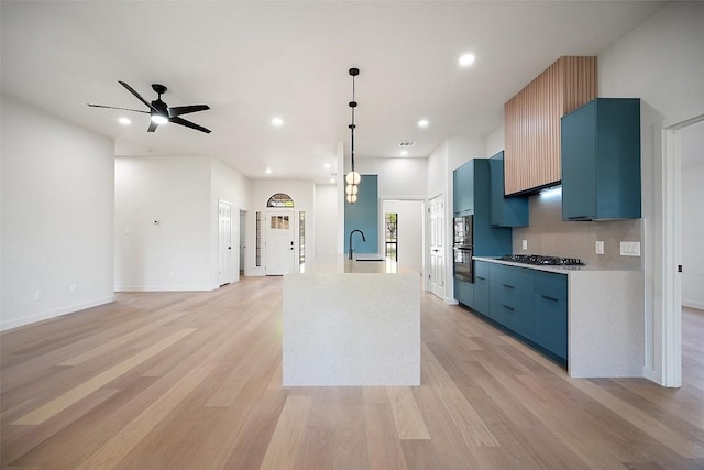 11107 Amblewood Way, Austin, TX 78753 - kitchen with blue cabinetry, modern cabinets, a sink, light wood finished floors, and recessed lighting
