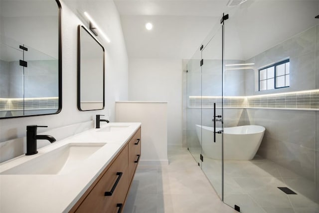 11107 Amblewood Way, Austin, TX 78753 - bathroom with a freestanding tub, double vanity, a shower stall, tile walls, and tile patterned floors