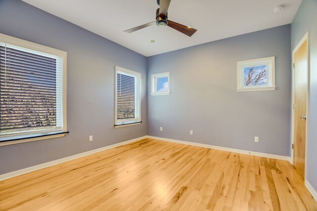 spare room with baseboards, a ceiling fan, and light wood finished floors
