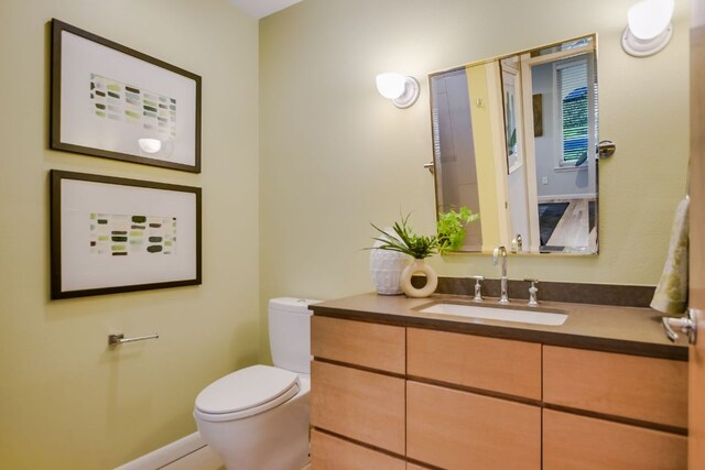 half bathroom with vanity and toilet