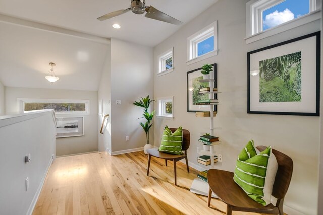 sitting room with ceiling fan, baseboards, an upstairs landing, and wood finished floors