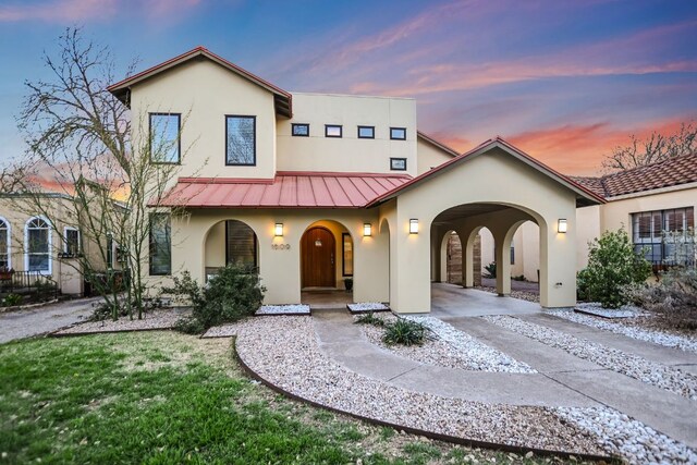 mediterranean / spanish home featuring a standing seam roof, stucco siding, and metal roof