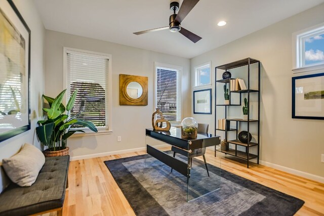 office area featuring a healthy amount of sunlight, baseboards, ceiling fan, and wood finished floors